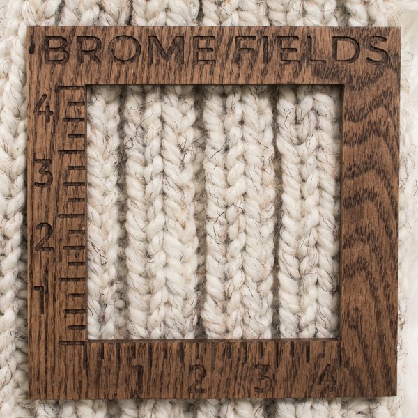 close-up of a knitted swatch with a wood gauge
