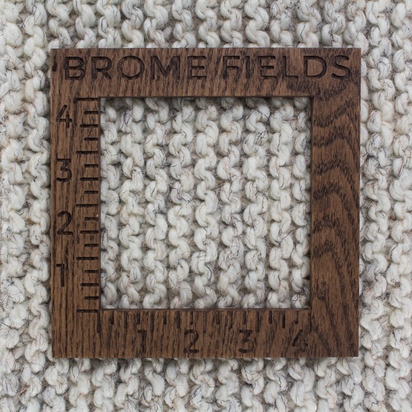 close-up of a knitted swatch with a wood gauge
