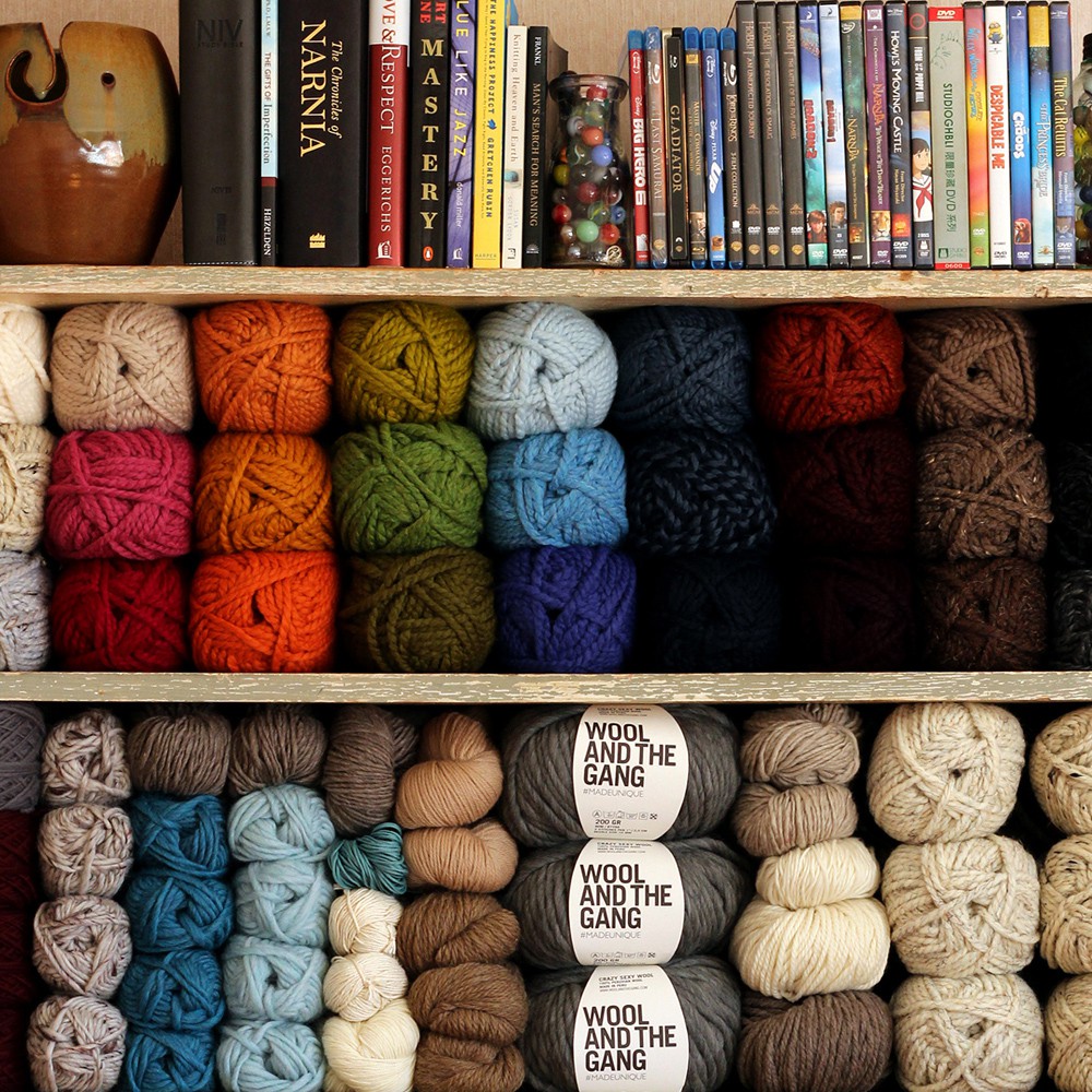 books, movies and yarn displayed on a book shelf