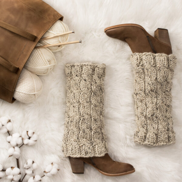 chunky cable knit leg warmers on a faux fur blanket in a cozy setting