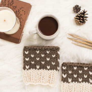 cozy scene of a cable knit boot cuffs on a faux fur blanket with coffee & a journal.