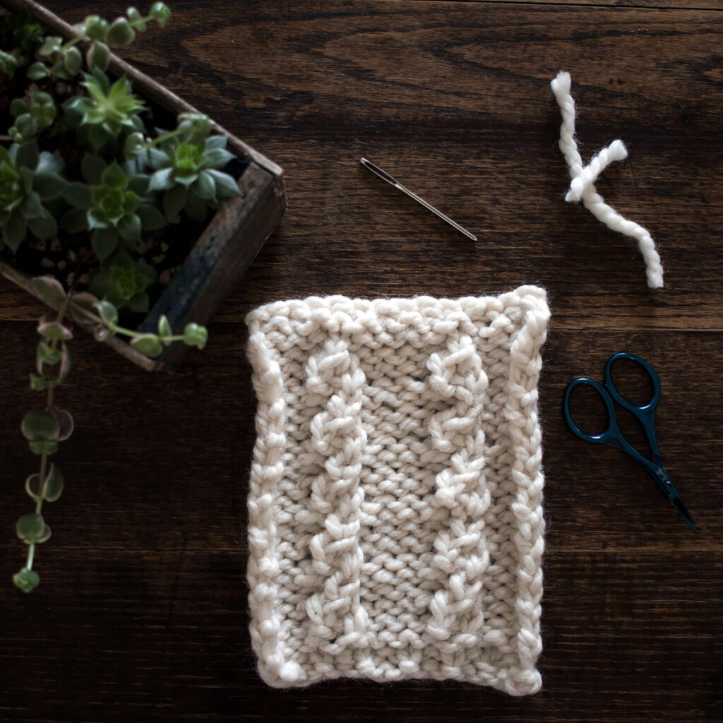 Swatch of the Mock Cable Knitting Stitch Pattern on a wood table.