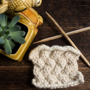 Swatch of the Lattice Knitting Stitch Pattern on a wood table.