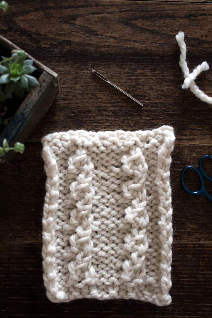 Swatch of the Mock Cable Knitting Stitch Pattern on a wood table.