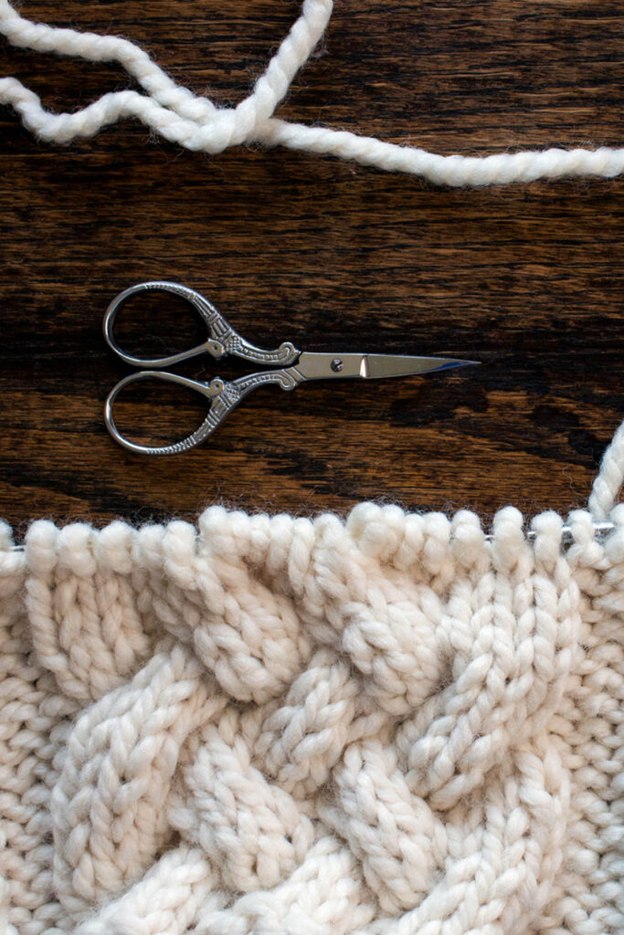 Swatch of the Braided Cable Knitting Stitch Pattern on a wood table