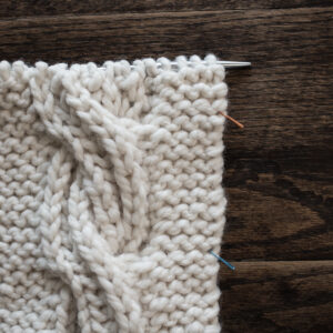 Swatch of the Brioche Cable Knitting Stitch Pattern on a wood table
