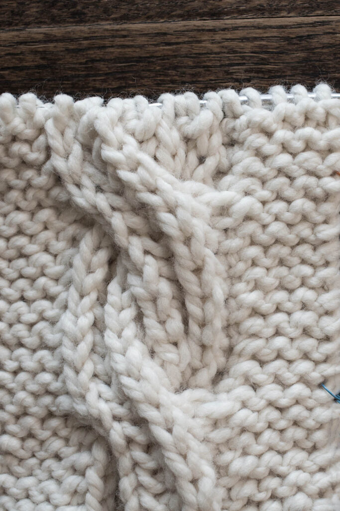 Swatch of the Brioche Cable Knitting Stitch Pattern on a wood table