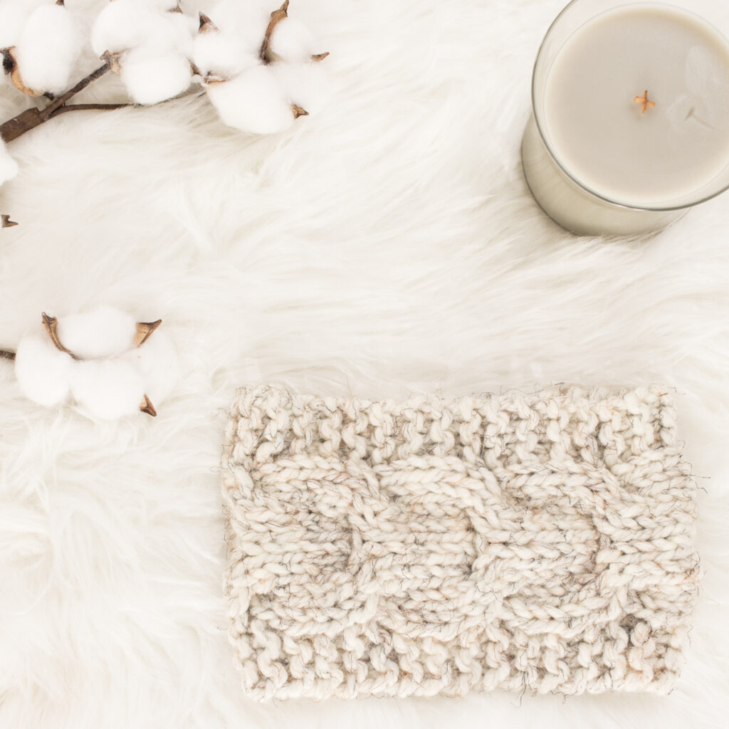 knitted horseshoe cable headband on a faux fur blanket
