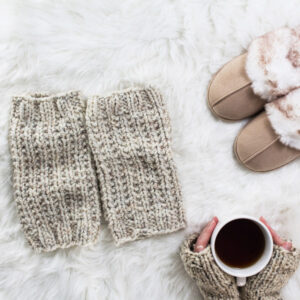 cozy scene of chunky cable knit leg warmers on a faux fur blanket