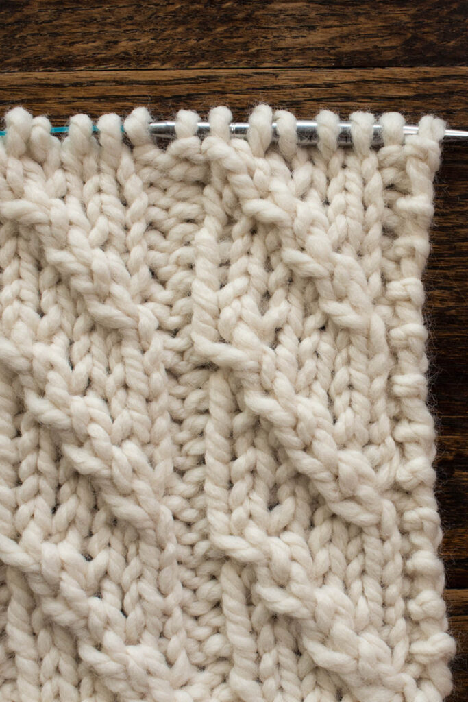 Swatch of the Diagonal Stripes Knitting Stitch Pattern on a wood table.