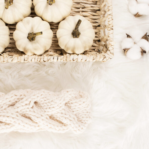 cable knit headband on a fur blanket with a basket of pumpkins