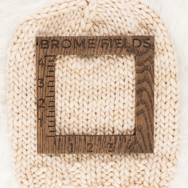 close-up of a knitted swatch with a wood gauge