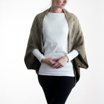 model wearing a hand knit, faded, worsted weight scoop shrug sweater