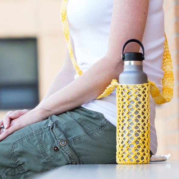 Knitted yellow water bottle sling in a hydro flask.