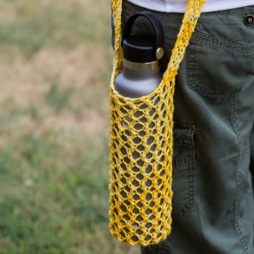 Knitted yellow water bottle sling in a hydro flask.