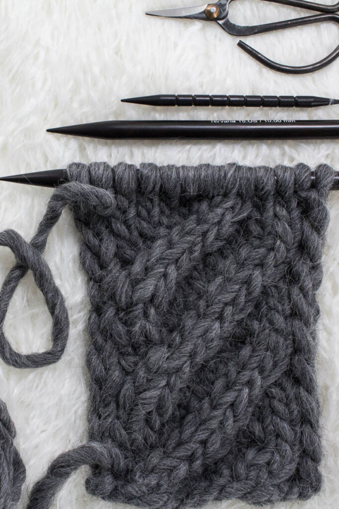 Swatch of the Basic 4-Step Cable Knit Stitch on a fur blanket.