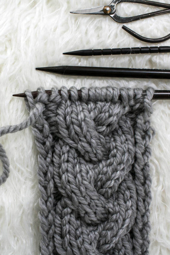 basic braid cable knit stitch swatch on a faux fur rug