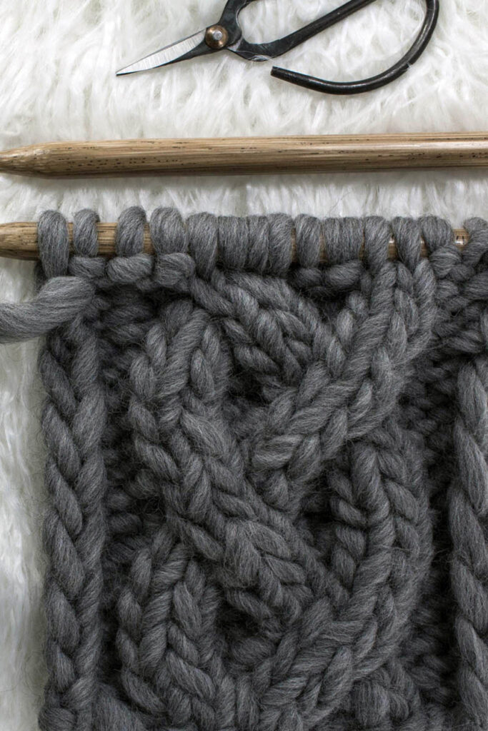 braided cable knit stitch swatch on a faux fur rug
