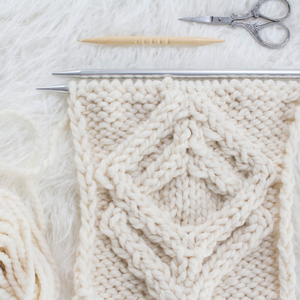 swatch of double diamonds cable knit stitch on a fur blanket