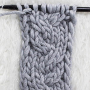 Swatch of the Garden Path Cable Knit Stitch on a fur blanket.