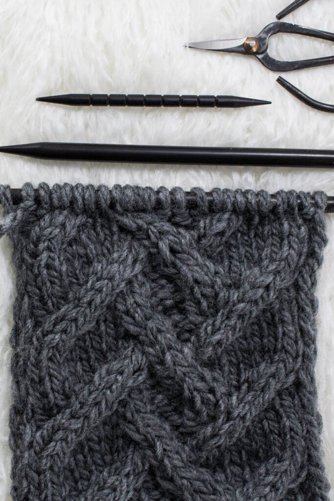 swatch of lattice herringbone cable knit stitch on a fur blanket