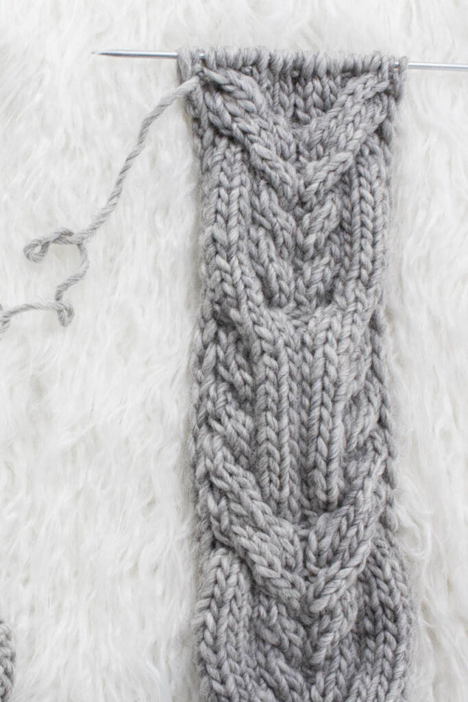 Swatch of the Interlaced Cables Cable Knit Stitch on a fur blanket.