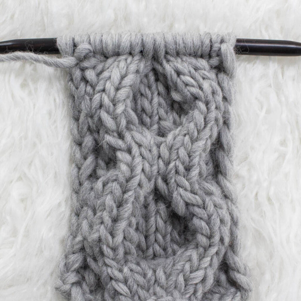 Swatch of the Large Circle Cable Knit Stitch on a fur blanket.