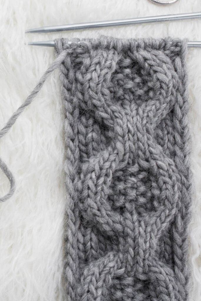 Swatch of the Medallion Cable Knit Stitch on a fur blanket.