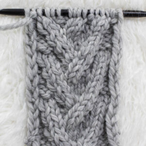 Swatch of the Open V-Stitch Cable Knit Stitch on a fur blanket.