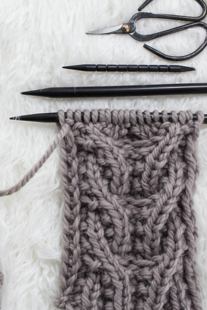 Swatch of the Side-by-Side Seed Cable Knit Stitch on a fur blanket.