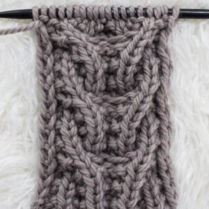 Swatch of the Side-by-Side Seed Cable Knit Stitch on a fur blanket.