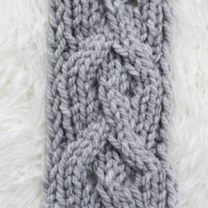 Swatch of the Twisted Eyelet Cable Knit Stitch on a fur blanket.