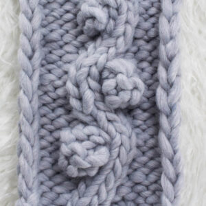 Swatch of the Wavy Bobble Cable Knit Stitch on a fur blanket.