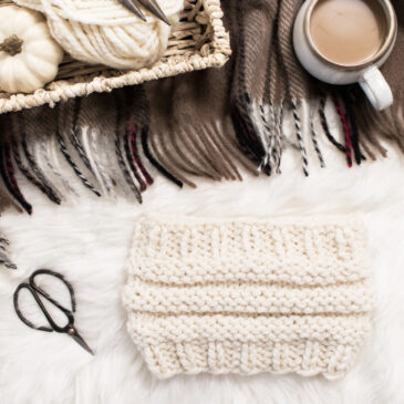 Messy bun headband knitting pattern on a flannel blanket with a cup of coffee.