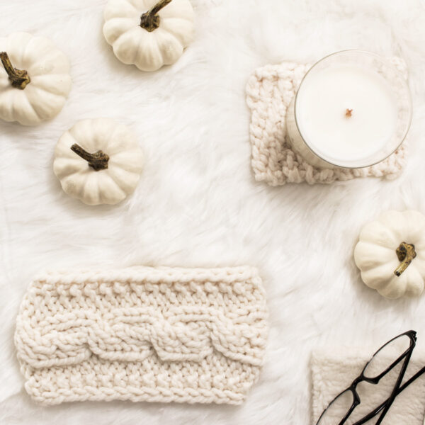 cable knit headband on a fur blanket with pumpkins & a candle