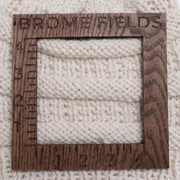 knitted swatch with a wood gauge