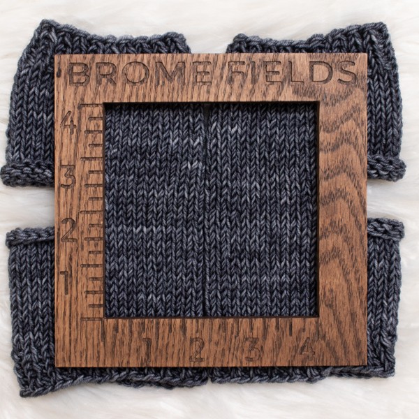 knitted swatch with a wood gauge