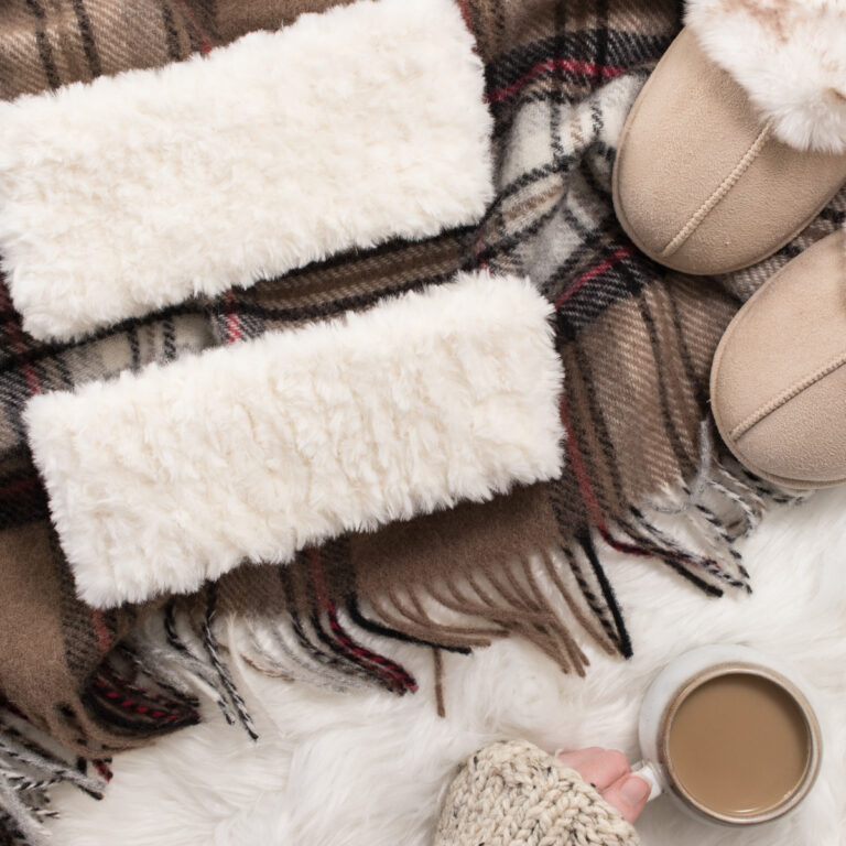 faux fur headband knitting pattern on a flannel blanket with a cup of coffee.