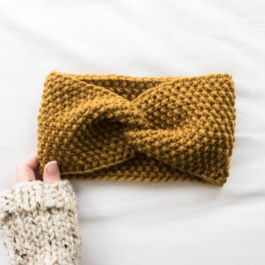 model wearing a chunky seed stitch headband with a messy bun