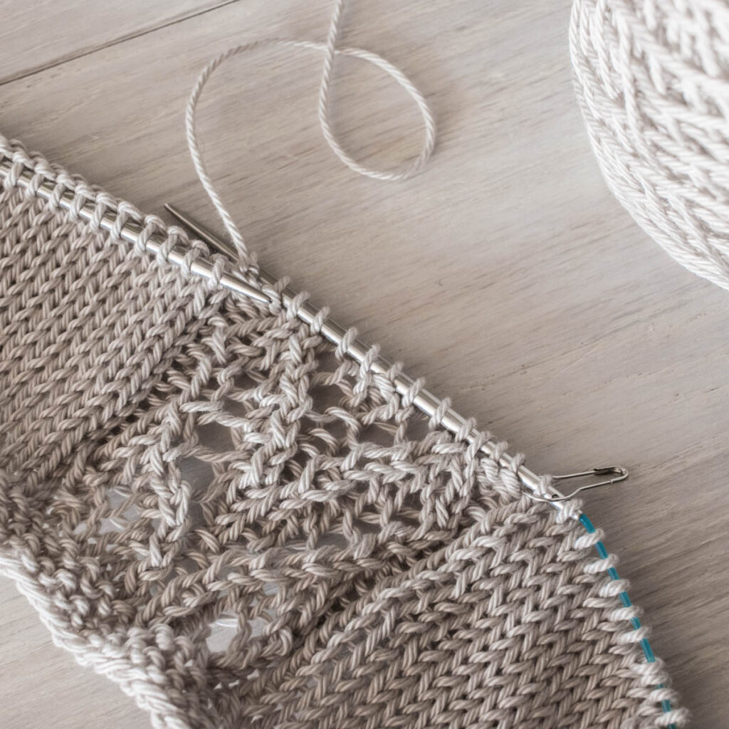 Partially knitted lace project on a table.