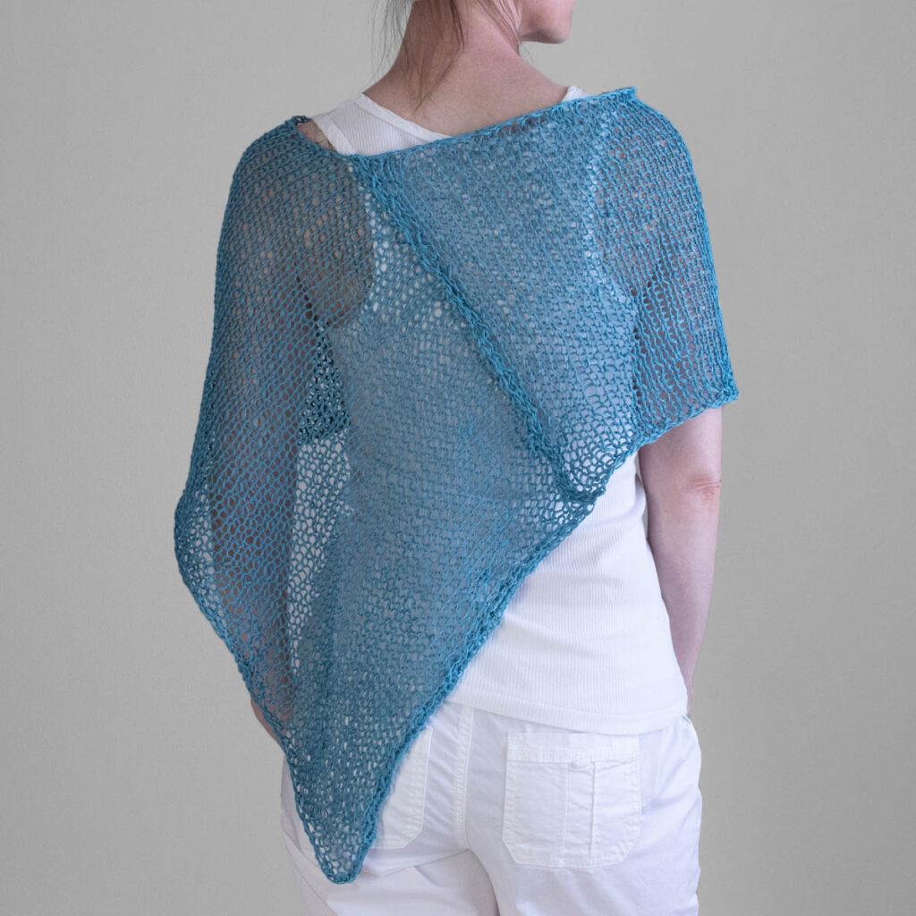 Back view photo of the hand knit poncho on a model.
