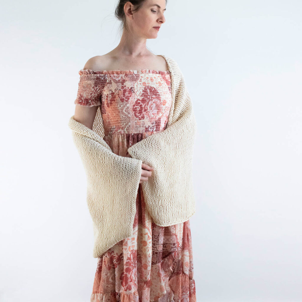 Front view of a lightweight cotton knit shrug worn over a summer dress