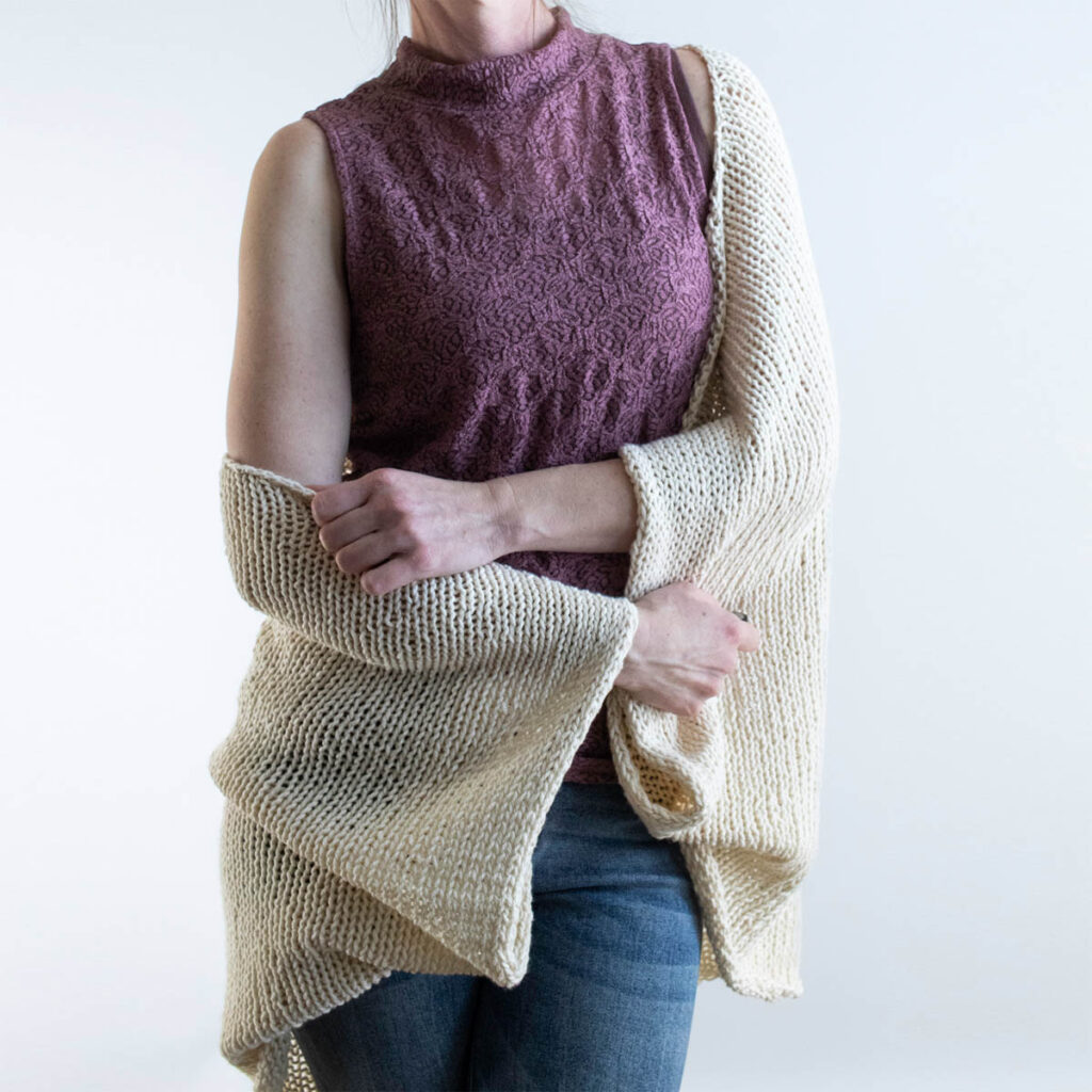 Beginner cotton knit shrug worn over a tank top.