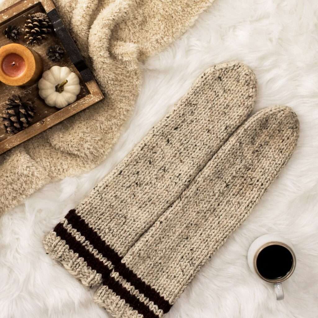 a cozy setting with chunky knit socks, coffee, candles and a blanket.