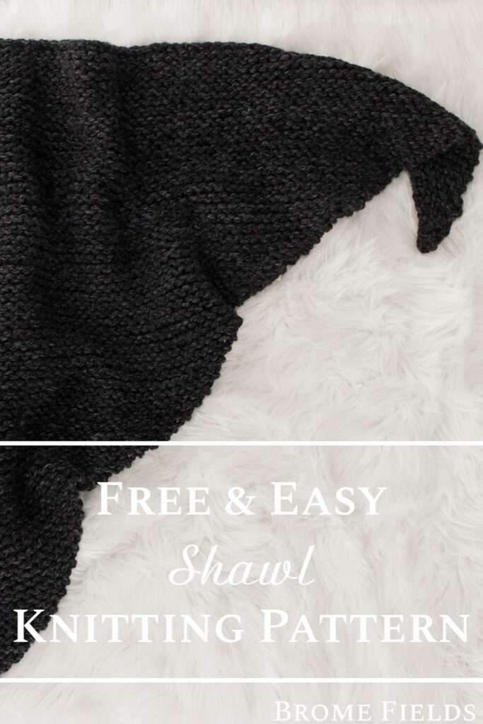 chunky knitted shawl laying on a fur rug