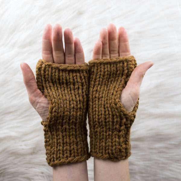 hand model wearing chunky fingerless gloves on a faux fur blanket