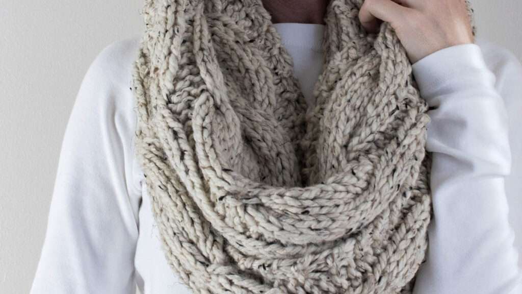close up of a model wearing a chunky cable knit infinity scarf