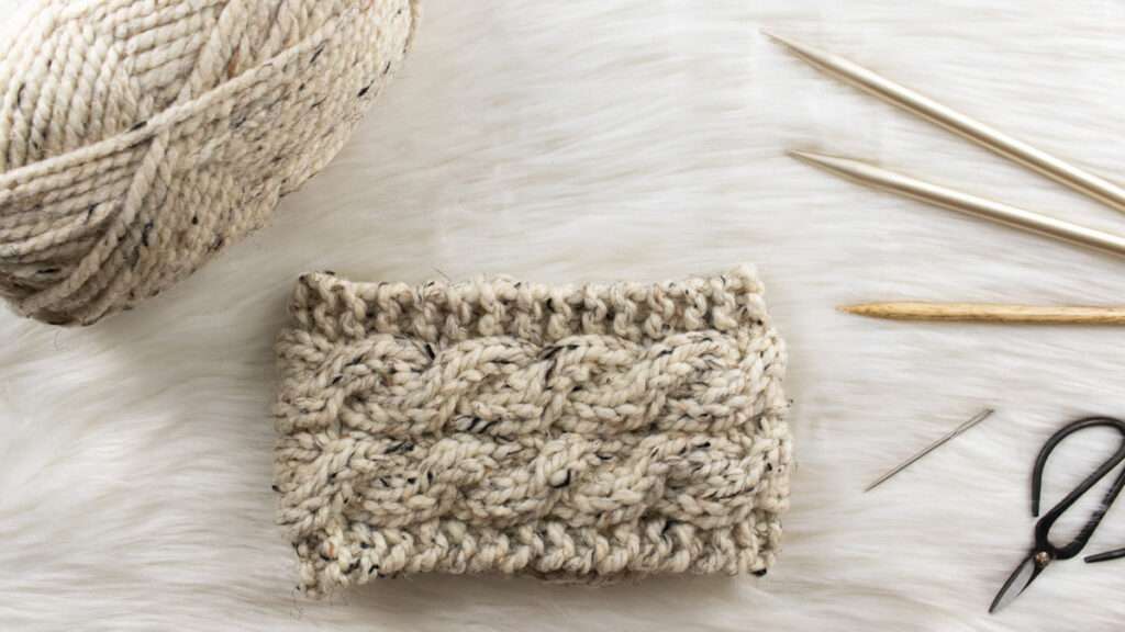 hand knitted cable headband on a faux fur blanket