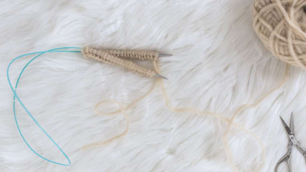 knitted magic loop method swatch on faux fur blanket
