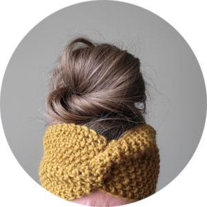 Messy bun wearing a hand knit seed stitch twist headband